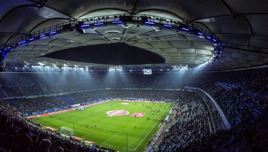 Pełny stadion piłkarski pod sztucznym oświetleniem podczas wieczornego meczu