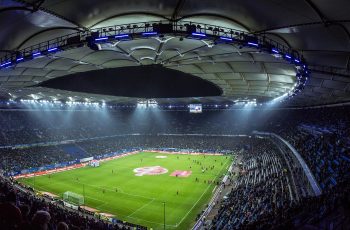 Pełny stadion piłkarski pod sztucznym oświetleniem podczas wieczornego meczu