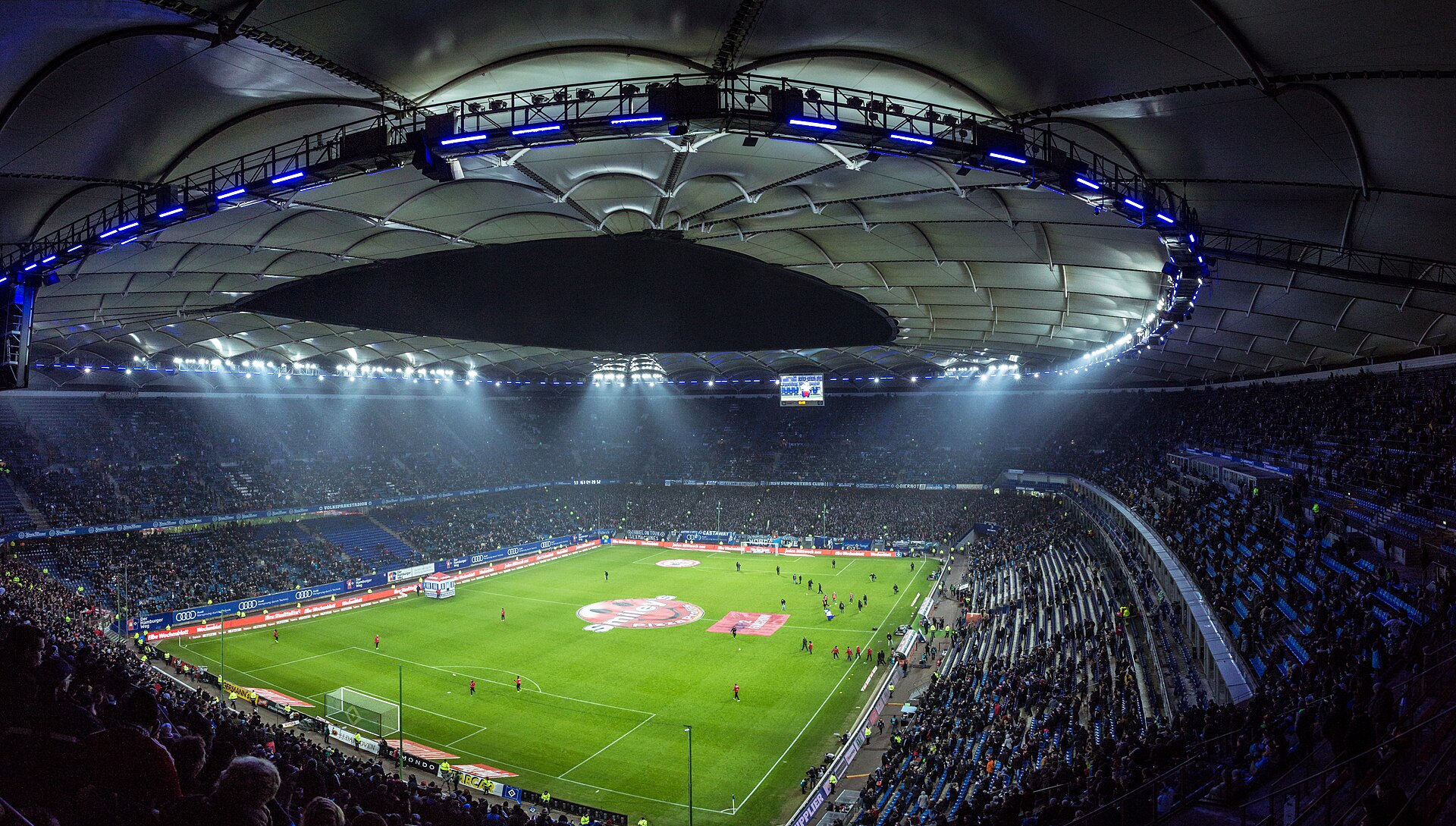 Pełny stadion piłkarski pod sztucznym oświetleniem podczas wieczornego meczu
